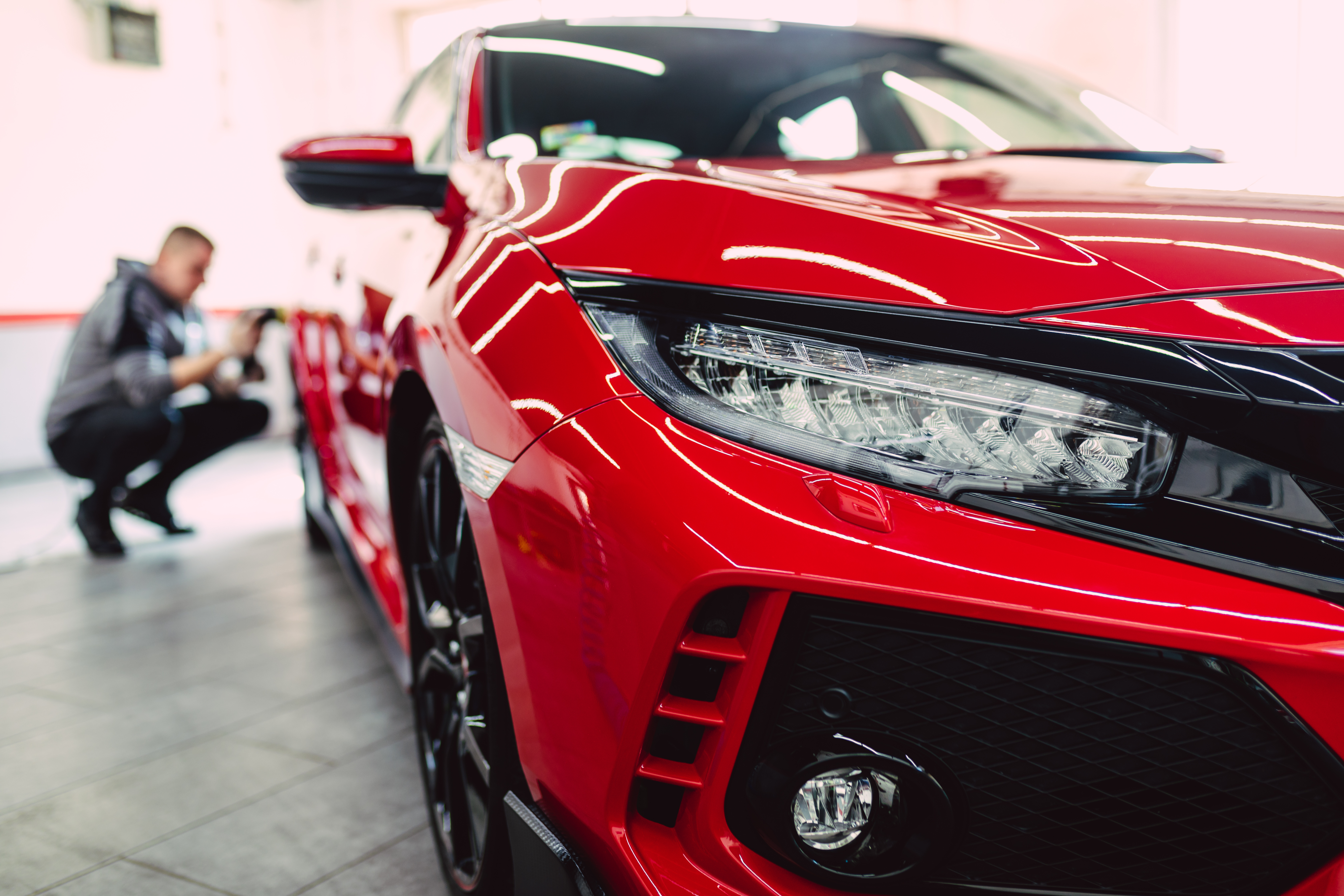 Acabado de un automóvil rojo en taller de repintado